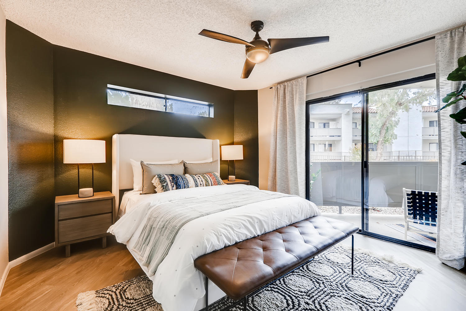 clean modern bedroom with ceiling fan and patio doors