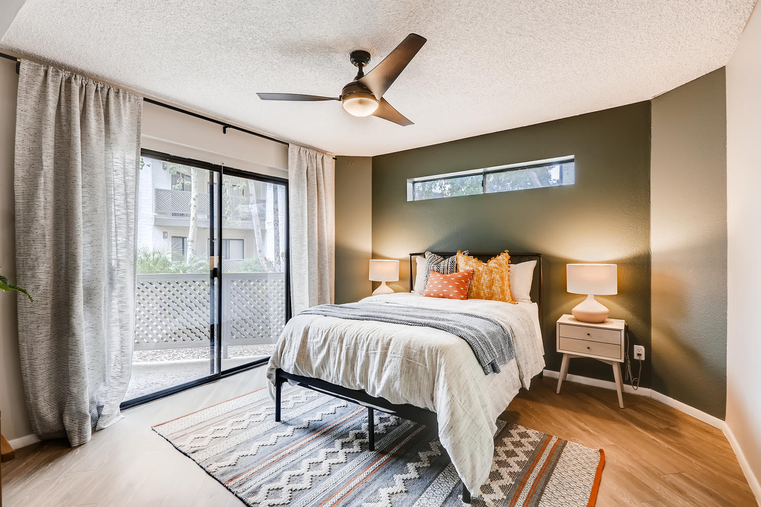 clean modern bedroom with ceiling fan and patio doors